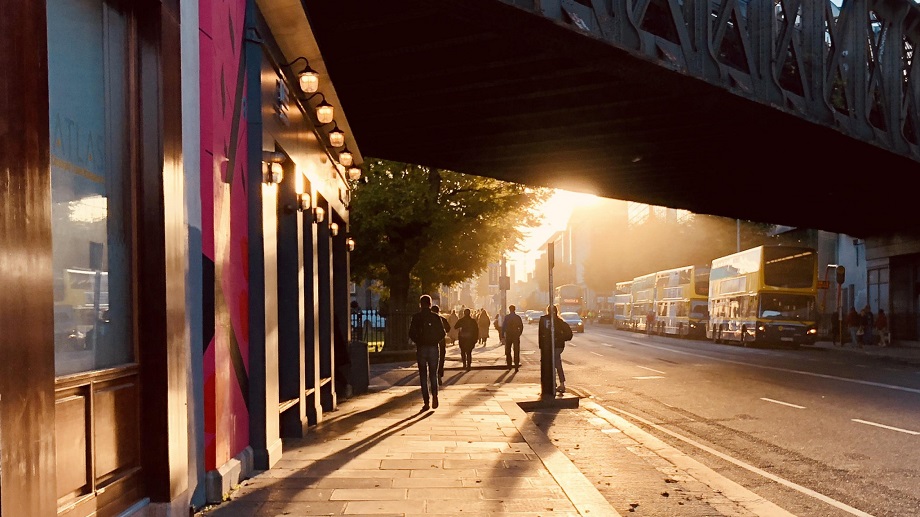A man walking down Pearse Street at sunset